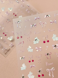 Macro detail of sweet pink rabbit and bow nail stickers with sparkling rhinestones