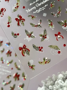 Detailed macro of 5D embossed Christmas nail stickers featuring bows and snowflakes