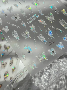 Macro shot of holographic butterfly nail stickers with rhinestones and laser effects