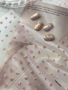 Detail view of 3D embossed pink and yellow floral nail art stickers with gold beads