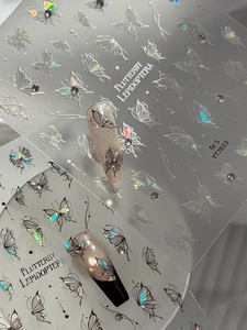 Detail view of holographic butterfly nail stickers with laser effect and 3D crystal accents