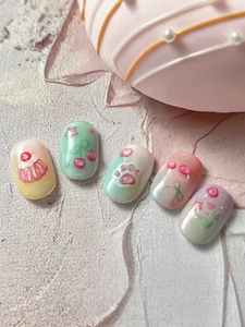 Vue macro de charmes d'ongles 3D en forme de patte de chat et de cupcake rose