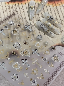 Detail of gothic baroque nail art stickers with gold and silver metallic crosses and hearts