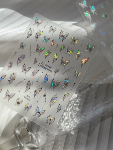 Iridescent butterfly nail stickers with laser effect shown on a glass background
