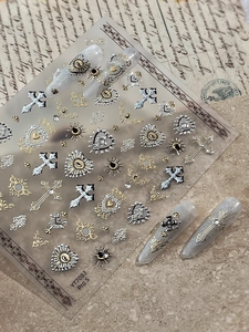 Macro detail of Baroque gold and silver embossed nail art stickers with gothic crosses