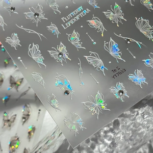 Holographic butterfly nail stickers with crystal accents on a textured background