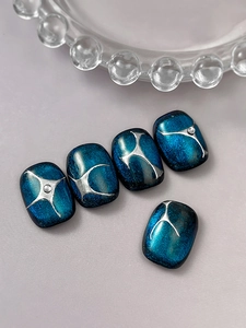 Detail of dark blue cat-eye nails with silver moon stars and 3D metallic lines