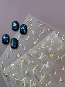 Macro shot of silver and gold star nail art stickers on blue marble nails