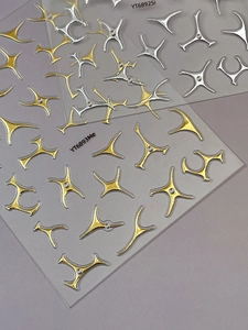 Detail view of 3D metallic nail stickers featuring Y2K starbursts and mini rhinestones