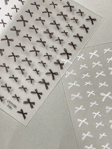 Detail of bow-knot nail stickers in black and white with silk texture on film