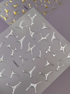 Macro detail of 3D silver metallic nail stickers with rhinestones and Y-shaped curves