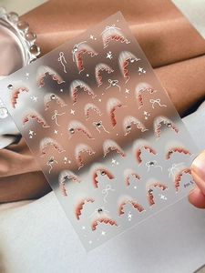Dettaglio degli adesivi per unghie stile francese con sfumature rosse e strass 3D