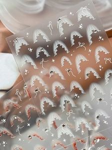 Dettaglio di adesivi per nail art in pizzo bianco con strass 3D e motivi velati