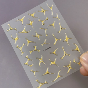 Minimalist gold starburst nail art stickers with small rhinestones and metallic lines