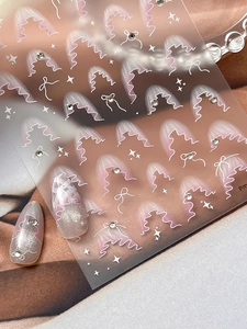 Dettaglio di adesivi per unghie in rete glitterata con onde rosa e fiocchi di cristallo