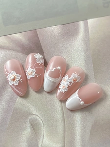Detail von 3D-Präge-Blumennägeln mit Perlen auf hautfarbenen French-Tip Kunstnägeln im Set