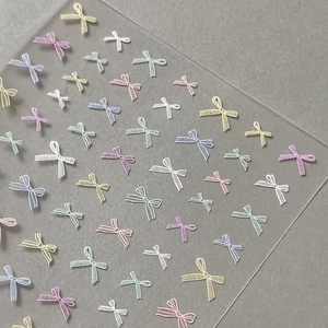 Pastel bow nail art stickers with textured grid patterns in various macaron colors