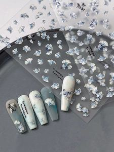 Macro detail of 3D embossed ginkgo leaf nail art stickers with gold foil outlines