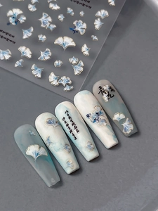 Macro detail of gingko leaf nail art stickers with calligraphy on matte false nails