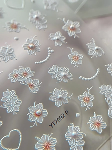 Makroansicht der 5D-geprägten Nagelaufkleber mit weißen Blumen und Perlenakzenten