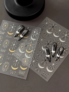Detailed view of silver cross nail art stickers with radiant rays and crescent moon motifs