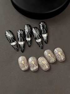 Detail view of gothic style silver cross and radiant lines on black pointed press-on nails