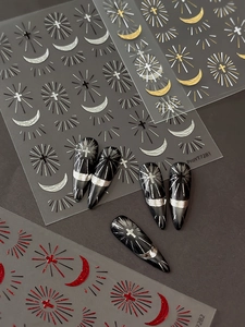 Macro detail of cross and star nail stickers in gold, silver, and red metallic finishes