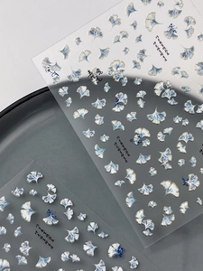 Detail of ginkgo leaf nail art stickers with gold foil outlines and blue porcelain style