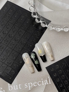 Detail of 3D embossed maple leaf nail stickers with gold and black autumn foliage patterns