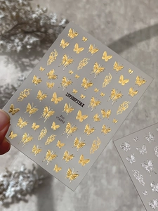 Macro detail of YT6993 gold and silver embossed butterfly nail art stickers with relief texture