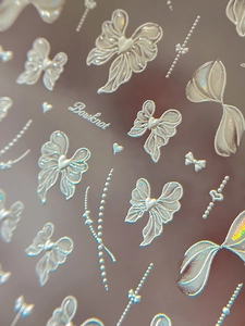 Vue macro d'autocollants 3D gaufrés blancs à nœuds et cœurs avec finition laser