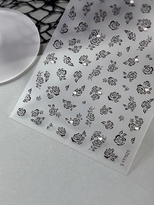 Detailed close-up of rose nail art stickers with rhinestones on matte backing sheet
