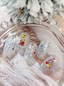 Détail du nail art de Noël avec flocons d'argent 3D et bonhomme de neige sur base givrée