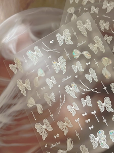 Détail macro des autocollants d'ongles en relief 3D avec nœuds irisés et perles douces