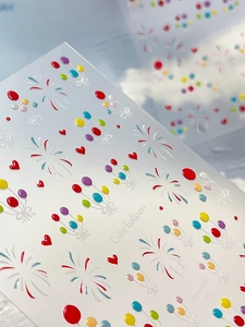 Macro detail of 3D embossed nail stickers featuring colorful balloons and fireworks