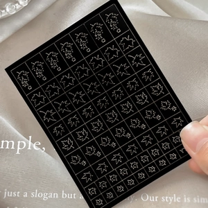 Hollow maple leaf nail art stickers with metallic silver outlines on black background