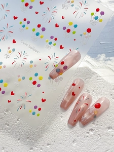 Macro detail of colorful balloon and firework nail art stickers on long almond nails