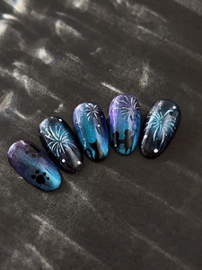 Detail view of fireworks nail art stickers featuring cat eye blue galaxy and silhouette designs