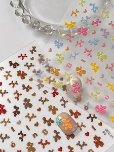 Détail d'autocollants 3D pour ongles avec chiens ballons, cœurs et étoiles au fini brillant