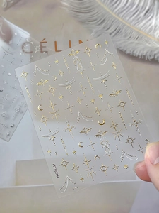 Dettaglio macro degli adesivi per unghie YT101Me oro e bianchi bohémien con luna e stelle