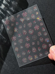 Detailed close-up of colorful laser firework nail stickers with holographic shell shine
