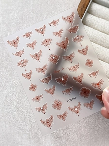 Detailed close-up of Baroque Lace nail art stickers with red patterns and pearl accents