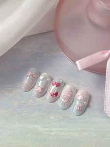 Detailed macro view of 3D pink bow and bear motifs on gradient pearlescent press-on nails