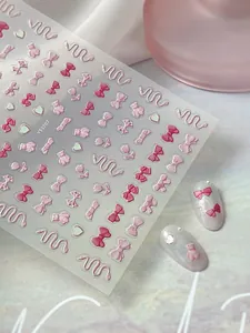 Macro shot of 5D embossed pink bow and bear nail stickers with 3D texture details