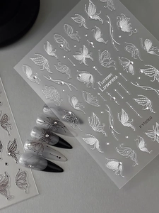 Macro detail of embossed butterfly nail stickers with sparkling rhinestones and silver lines