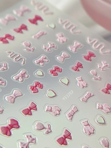 Macro shot of pink 3D embossed nail stickers with bows hearts and bears detail