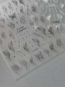 Detailed macro view of black and white embossed butterfly nail stickers with dot line patterns
