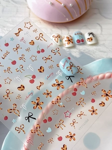 Vue détaillée d'autocollants nail art avec motifs nœuds léopard et cerises rouges