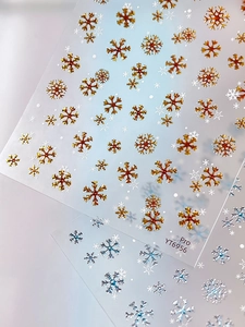 Macro detail of YT6956 Christmas nail stickers featuring gold and silver 3D snowflake patterns