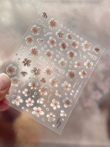 Detailed view of 5D embossed cherry blossom nail stickers with white and pink floral patterns